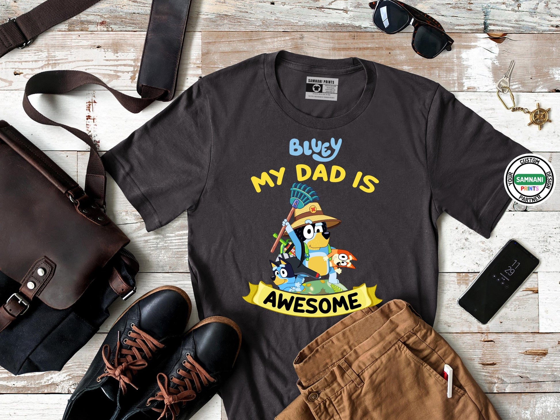 Funny Bluey Dad Shirt for Father’s Day Gift – This &quot;My Dad Is Awesome&quot; Bluey t-shirt features Bandit in a playful and colorful design, making it the perfect gift for dads who love Bluey. Made from soft, premium-quality fabric, this black graphic tee is comfortable for everyday wear. Whether for Father&#39;s Day, birthdays, or a fun matching family outfit, this Bluey dad shirt is a must-have for fans of the hit cartoon series and stylish dad apparel.