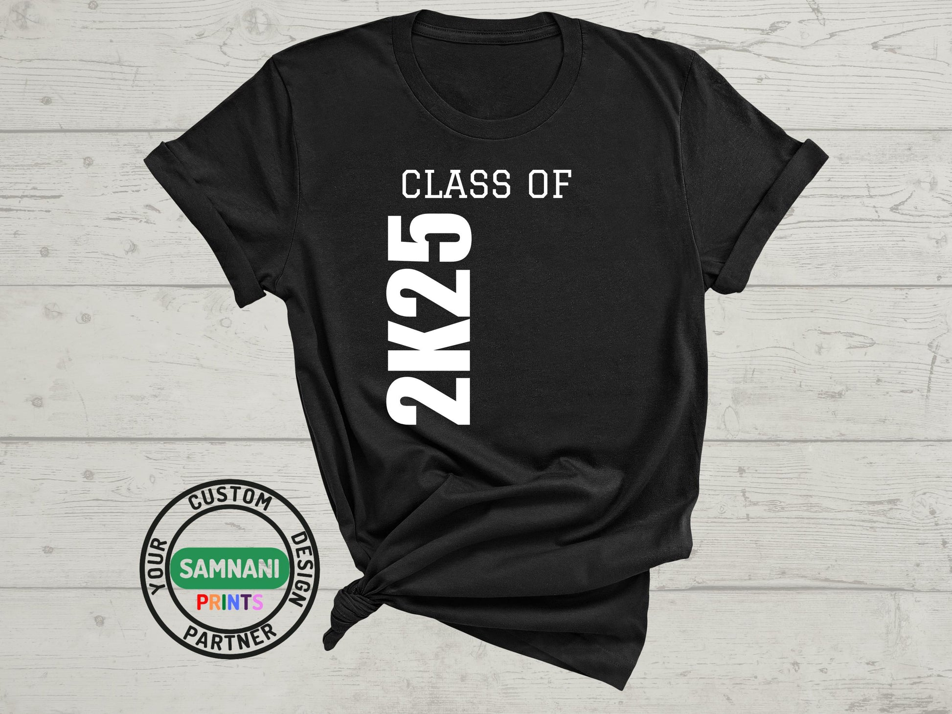 Black T-shirt featuring bold &#39;Class of 2K25&#39; text in a stylish, modern font. The shirt is made from soft, breathable fabric and is perfect for celebrating graduation year 2025. Available in various sizes for both men and women. A must-have keepsake for graduates and their supporters.