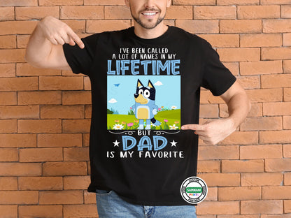 A man wearing a black t-shirt with a cartoon dad character in a field of flowers and text that reads “I’ve Been Called a Lot of Names in My Lifetime, But Dad Is My Favorite.”Bandit Bluey Dad Shirt – I&#39;ve Been Called Many Names Tee – Gift for Funny Dads. Father&#39;s Day gift, gift for dad, gift for paw paw, gift for father. Bluey Bandit T-shirt and sweatshirt.
