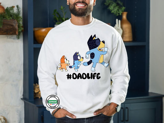 Man wearing a white sweatshirt featuring a cartoon-style dad and two kids walking together with stars above them, and the bold black text &quot;#DADLIFE&quot; underneath the characters. Bluey inspired t shirt sweatshirt for DAD. Father&#39;s Day gift, Kids cartoon father and daughter gift, gift for father&#39;s day under $20